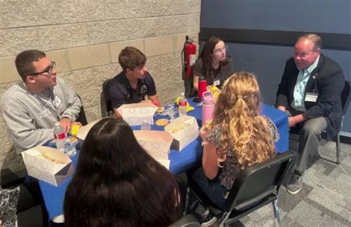 Jack Davis, Holten Graham, Jocelyn Lerma, and Sullivan Morris having a conversation with one of the forum speakers.